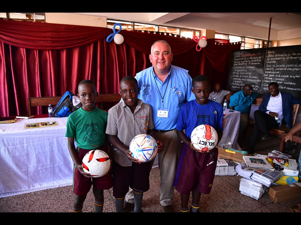 Pastor Joel giving volleyballs to the Makindye School